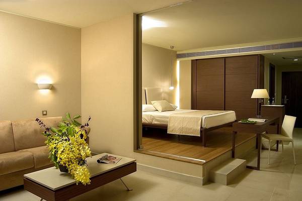 Suite-Schlafzimmer im Olympic Palace Resort mit Bett, Wohnzimmer und Schreibtisch.