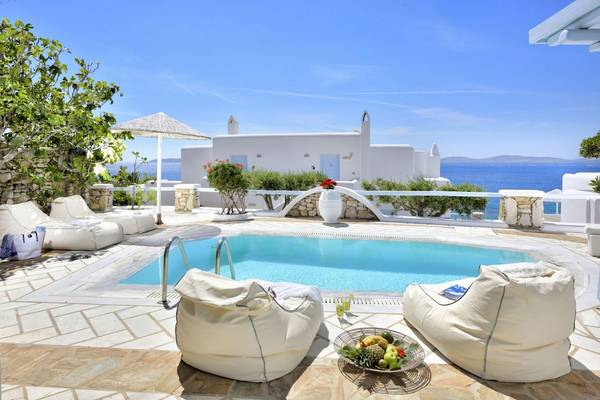 Außenpool-Terrasse mit weißen Liegestühlen und Ausblick auf das Meer, Saint John Hotel Villas & Spa