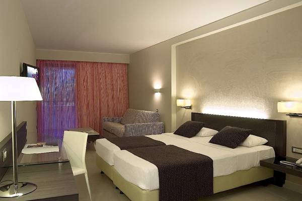 Hotelzimmer im Olympic Palace Resort mit zwei Betten, Sofa und Fernseher.