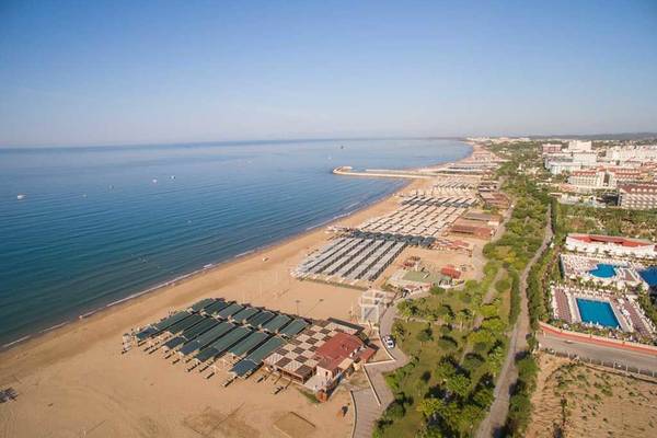 Außenansicht des Side Crown Palace Hotels mit Strand, Meer und Gebäuden