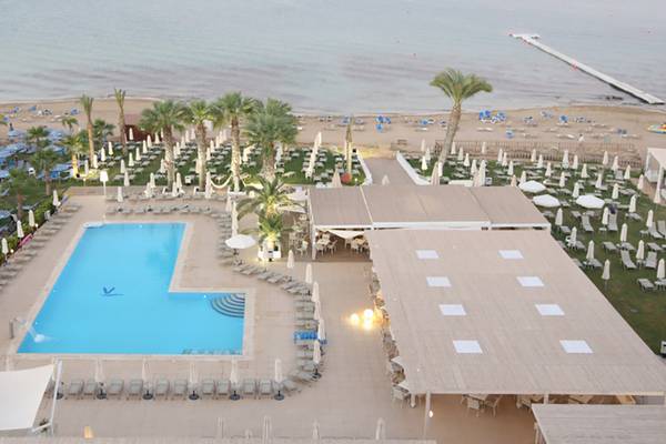 Luftaufnahme des Vrissiana Beach Hotels mit Pool, Liegestühlen und Gebäuden am Strand