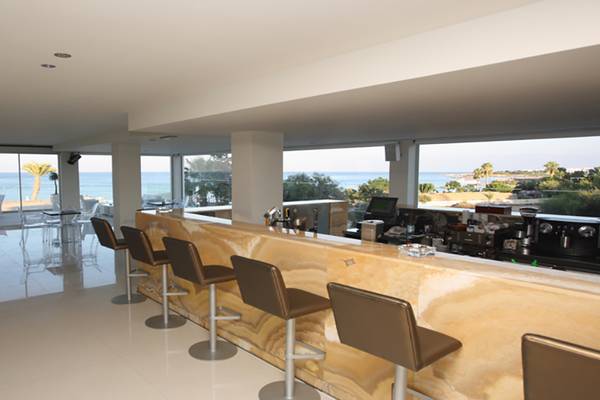 Innenansicht der Bar im Vrissiana Beach Hotel mit Blick auf das Meer.
