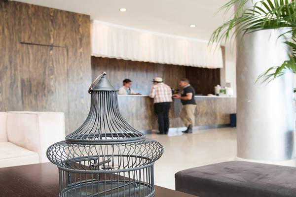 Empfangsbereich des Vrissiana Beach Hotels mit Gästen und Rezeptionisten.