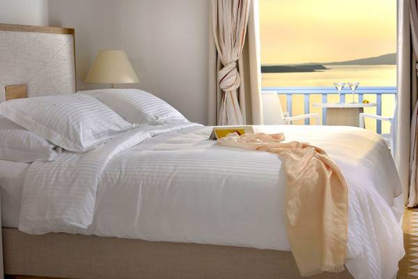 Schlafzimmer im Saint John Hotel Villas & Spa mit Blick auf das Meer und Inseln.