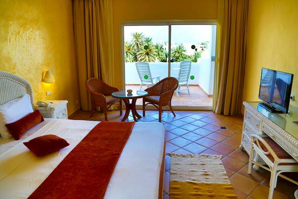Hotelzimmer im Odyssee Resort Thalasso & Spa mit Bett, Tisch und Fernseher auf dem Schreibtisch.