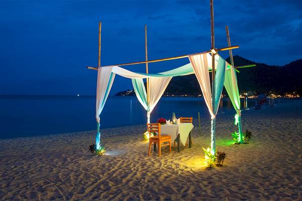 Dinner unter einer Gazebo auf dem Strand bei Nacht im Fair House Beach Resort.
