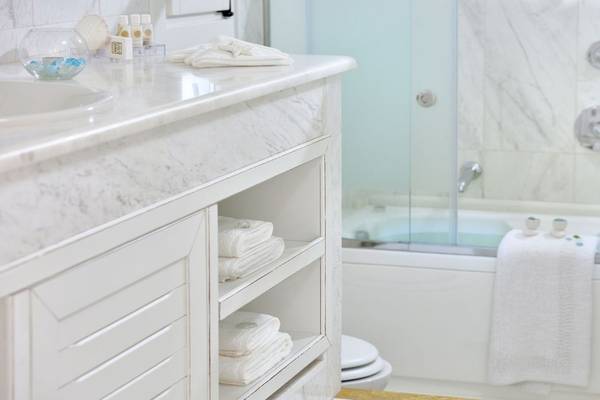 Badezimmer im Saint John Hotel Villas & Spa mit Marmorkommode, Dusche und Badewanne.