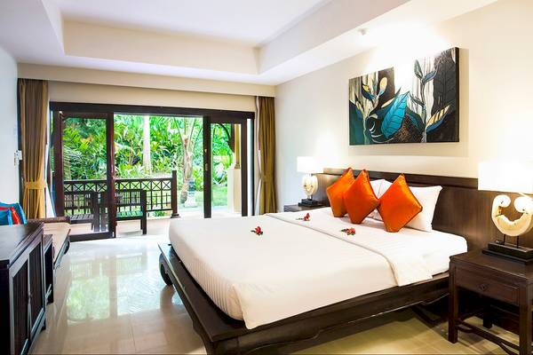 Schlafzimmer im Fair House Beach Resort mit Blick auf eine Terrasse und Garten