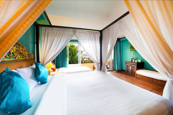 Doppelbett im Fair House Beach Resort mit vier Himmelbetten und Blick auf den Garten.