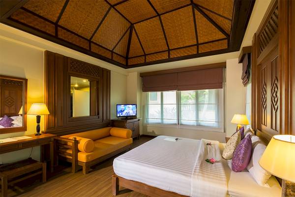 Schlafzimmer im Fair House Beach Resort mit Bett, Fernseher und Dekor.