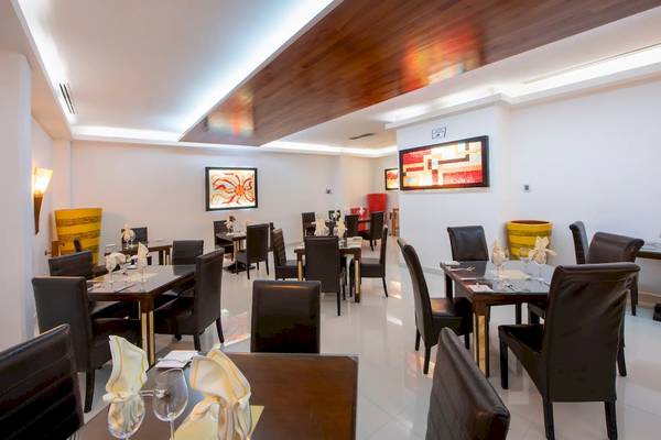Innenansicht des Viva Wyndham Maya Restaurants mit gedeckten Tischen und Stühlen.