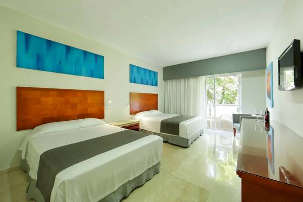 Doppelbettzimmer im Viva Wyndham Maya Hotel mit modernen Möbeln und Blick auf den Garten.