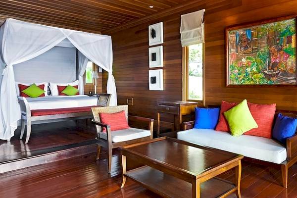 Innenansicht eines Zimmers im Hilton Seychelles Northolme Resort & Spa mit einem Bett, Möbeln und Dekor.