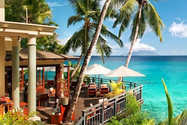 Außenbereich des Hilton Seychelles Northolme Resort & Spa mit Blick auf das Meer und Palmen