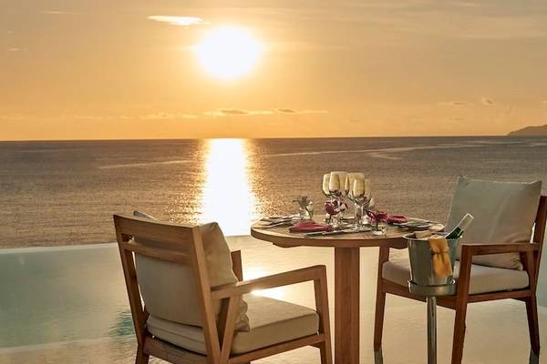 Meeresaussicht mit Sonnenuntergang und Tisch für zwei Personen im Hilton Seychelles Northolme Resort & Spa