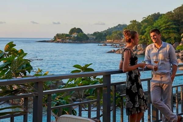 Paar auf der Terrasse des Hilton Seychelles Northolme Resort & Spa mit Blick auf das Meer