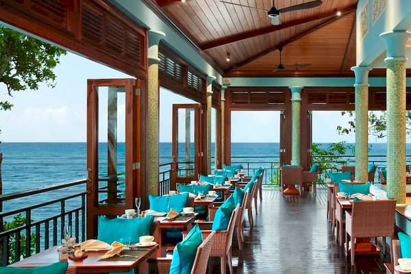 Das elegante Innenrestaurant des Hilton Seychelles Northolme Resort & Spa mit Blick auf das Meer.