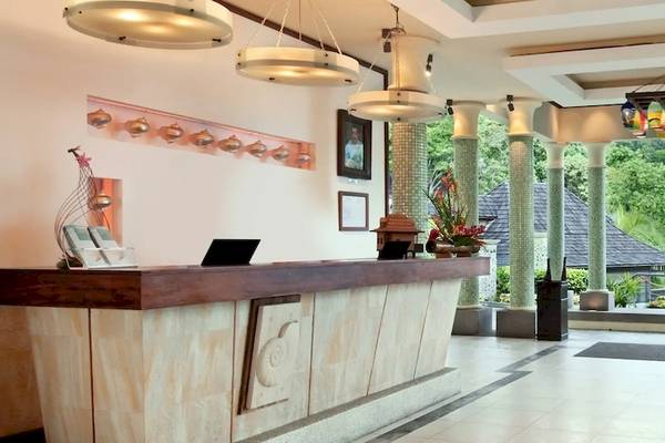 Empfangsbereich des Hilton Seychelles Northolme Resort & Spa mit modernem Design und Blick auf einen Garten.