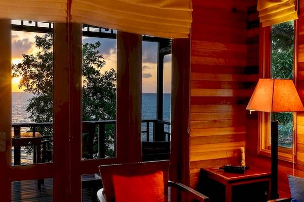 Innenraum des Hilton Seychelles Northolme Resort & Spa mit Blick auf das Meer und einen Sonnenuntergang.