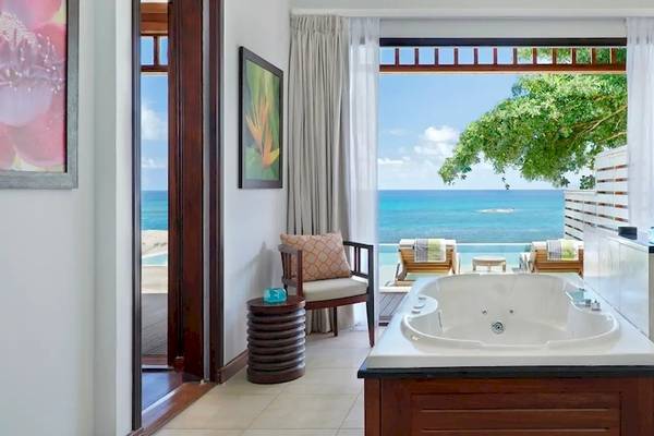 Badezimmer mit Außenzugang im Hilton Seychelles Northolme Resort & Spa mit Blick auf den Ozean.
