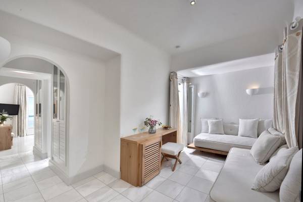 Innenansicht des Saint John Hotel Villas & Spa mit weißen Möbeln und Fliesenboden.