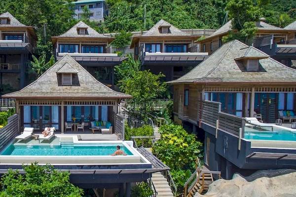 Luftaufnahme der Villen im Hilton Seychelles Northolme Resort & Spa mit Pools und Sonnenliegen.