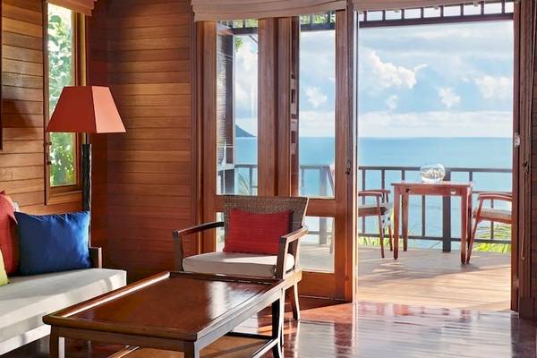 Wohnzimmer im Hilton Seychelles Northolme Resort & Spa mit Blick auf das Meer und einem Balkon.