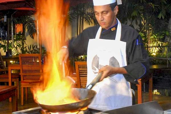 Koch vom Occidental Eden Beruwala brät mit einem brennenden Wok in der Hotelküche