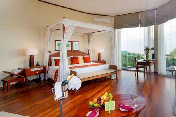Luxuriöse Suite im Occidental Eden Beruwala mit Blick auf das Meer, einem großen Bett und einer Terrasse.