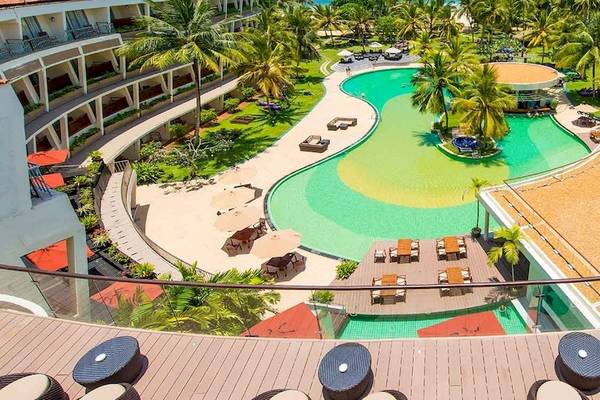 Aussicht auf das Occidental Eden Beruwala Resort mit Swimmingpool, Sonnenliegen und Gebäuden.