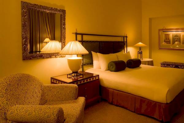 Hotelzimmer im Grand Hyatt Muscat mit Bett, Lampen und Möbeln.