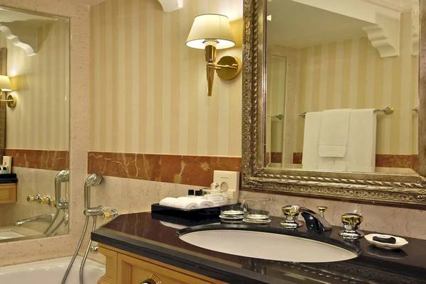 Badezimmer im Grand Hyatt Muscat Hotel mit Badewanne, Waschbecken und Spiegel.