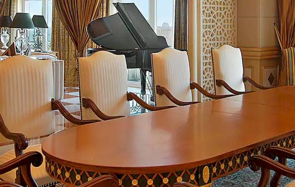 Besprechungsraum im Grand Hyatt Muscat mit Blick auf das Meer, einem Klavier und eleganten Stühlen.