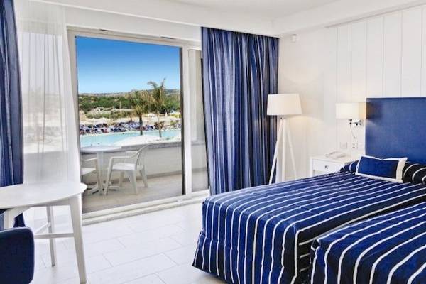 Doppelbettzimmer im db Seabank Resort & Spa mit Ausblick auf den Pool.