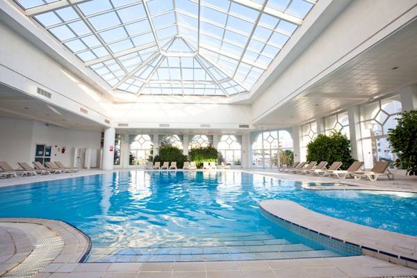 Innenpool des El Mouradi Hammamet Hotels mit Glasdach und Loungeliegen