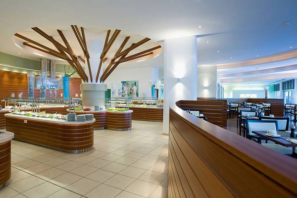 Innenansicht des Restaurants im Mediterranean Beach Hotel in Zypern mit Buffet und Tischen.