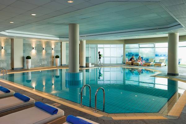 Innenpool des Mediterranean Beach Hotel in Zypern mit Loungebereich und Personen