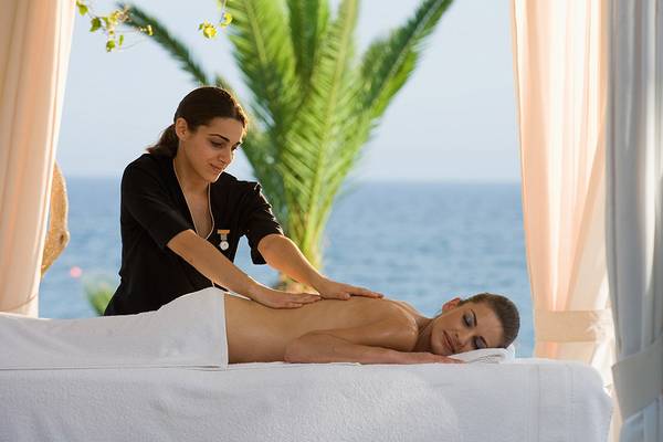 Eine Frau erhält eine Massage im Hotel am Strand mit Meerblick.