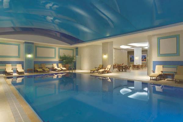 Innenbereich des Wyndham Grand Izmir Ozdilek Hotel mit Swimmingpool und Loungebereich