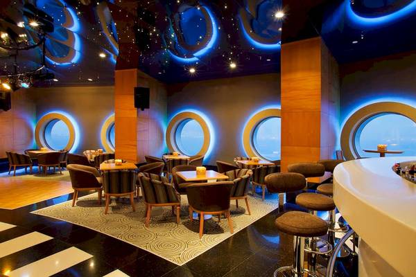 Innenbereich eines Hotels mit einer Lounge, runden Fenstern und modernen Möbeln.