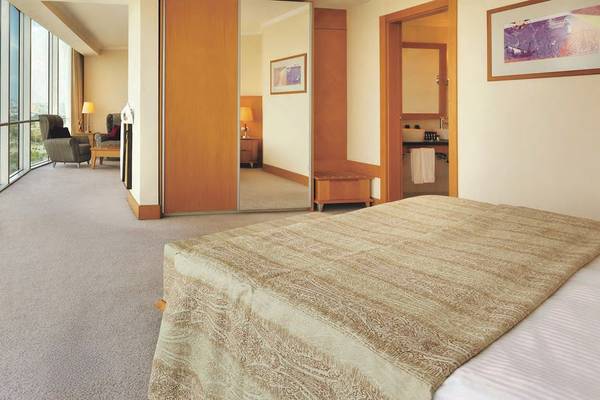 Schlafzimmer im Wyndham Grand Izmir Ozdilek mit großem Bett und Aussichtsfenstern.
