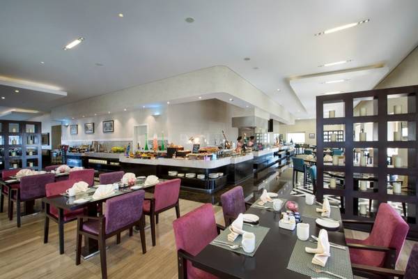 Innenansicht des Restaurants im Tower Plaza Hotel Dubai mit Tisch und Stühlen, Buffet und Personal.