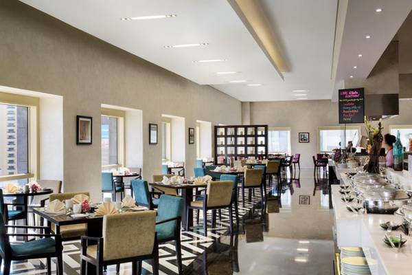 Innenansicht des Restaurants im Tower Plaza Hotel Dubai mit gedeckten Tischen und Buffet.