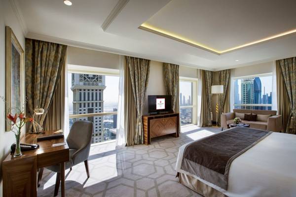 Innenansicht der Suite im Tower Plaza Hotel Dubai mit Schreibtisch, Stuhl und Fernseher.