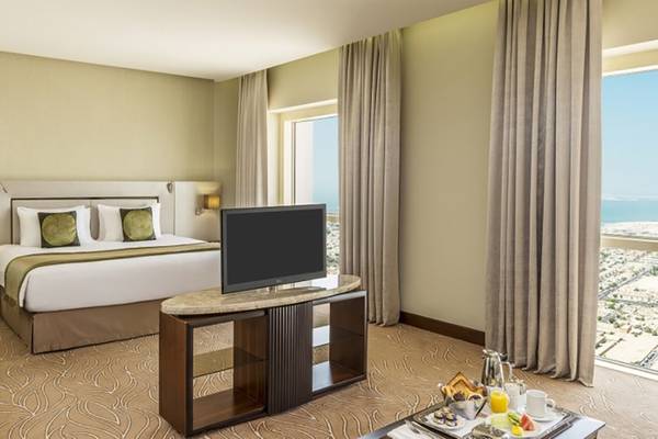 Hotelzimmer im Tower Plaza Hotel Dubai mit Aussicht auf das Meer.