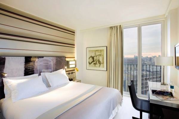 H10 London Waterloo Hotelzimmer mit Bett, Schreibtisch und Blick auf die Stadt.