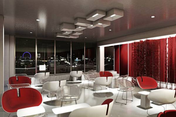 Inneneinrichtung des H10 London Waterloo Hotels mit roten und weißen Möbeln und großen Fenstern.