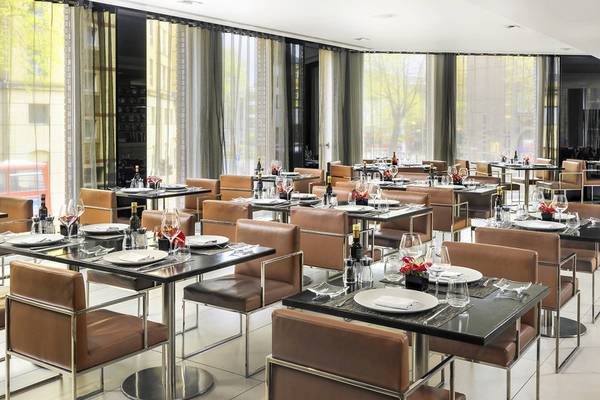Foto des Innenbereichs des Restaurants im H10 London Waterloo Hotel mit gedeckten Tischen und Stühlen.