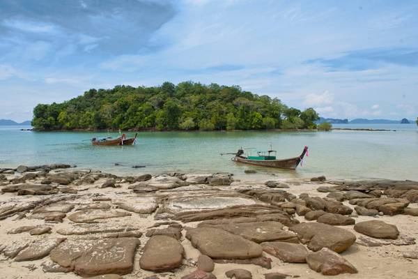 Strand mit Booten und einer kleinen Insel im Hintergrund, vor dem Beyond Resort Krabi