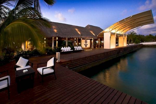 Terrasse des Sheraton Maldives Full Moon Resort & Spa mit Blick aufs Wasser und Palmen